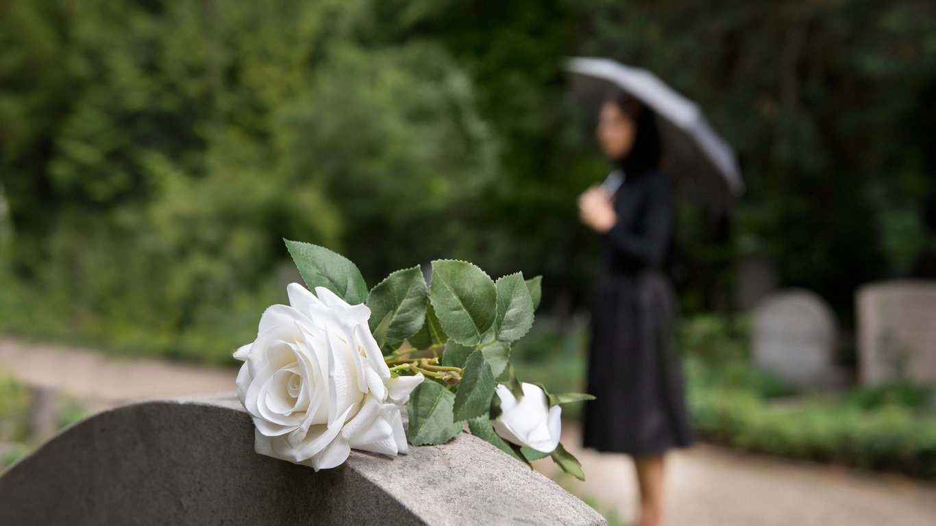 Женщина в черном, которая стоит на кладбище
