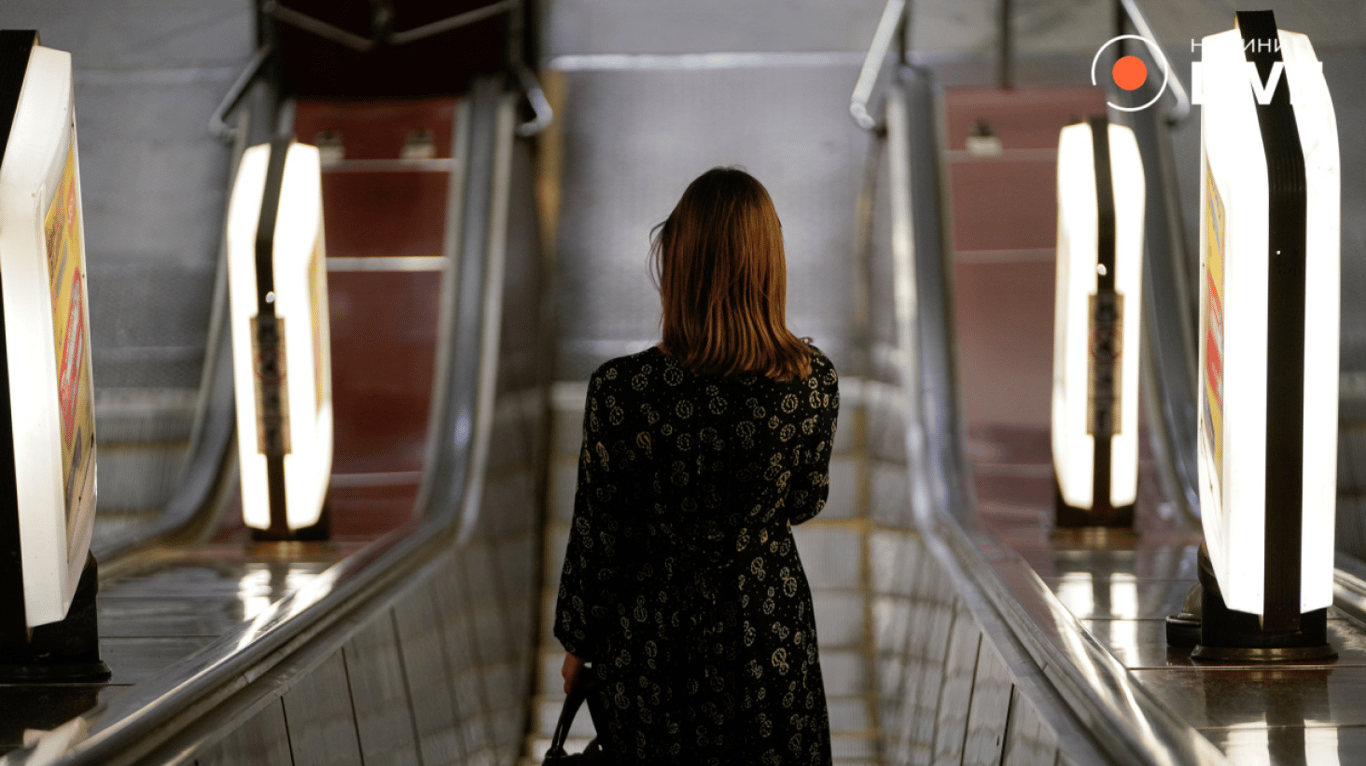 Женщина спускается в метро