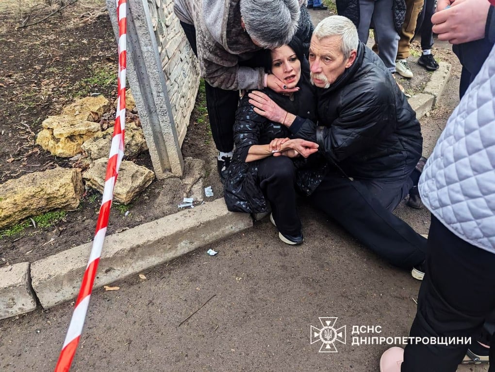 Люди помогают пострадавшей из-за обстрела в Кривом Роге