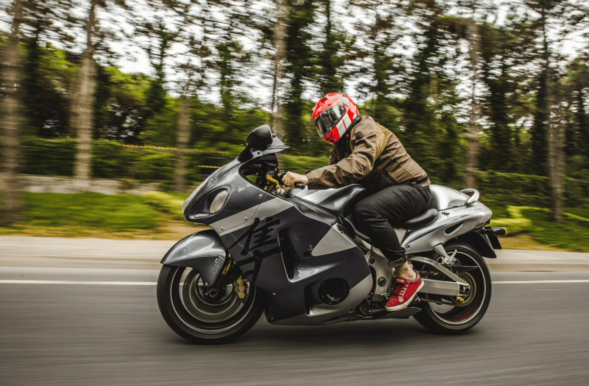 Мужчина, который едет на мотоцикле по дороге