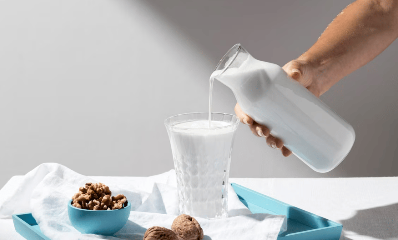 Человек, который наливает растительное молоко в стакан