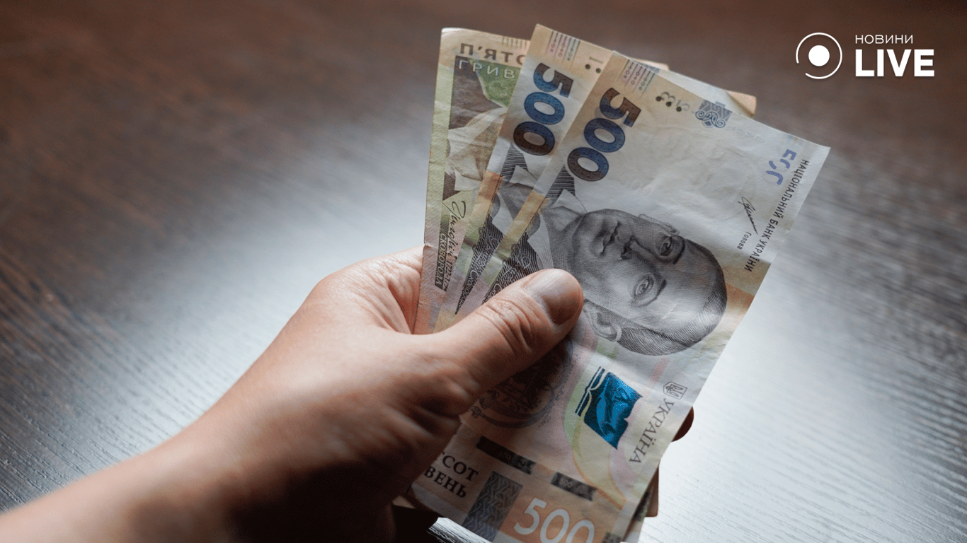 Людина тримає гроші