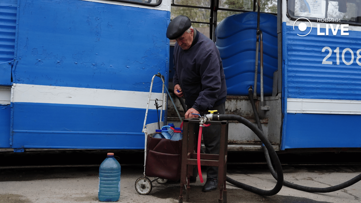 Мужчина набирает питьевую воду из специального трамвая. Фото: Новости.LIVE/ Юлия Браславская