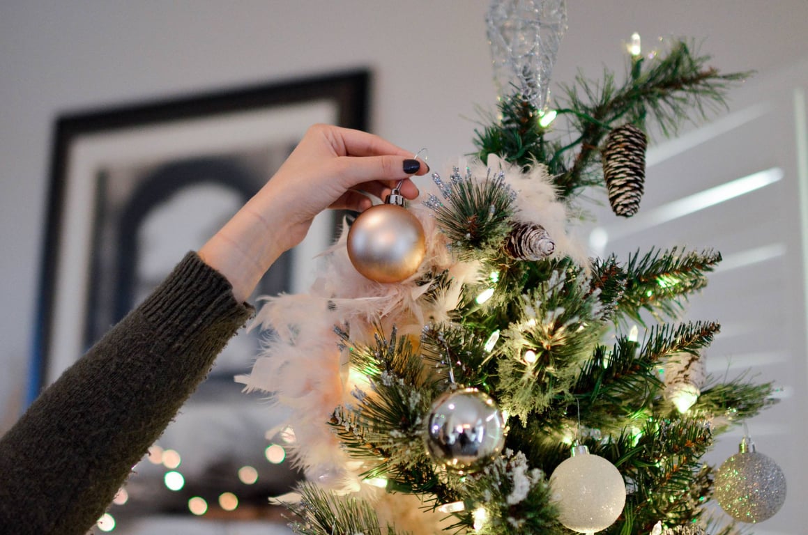 Женщина, украшающая новогоднюю елку