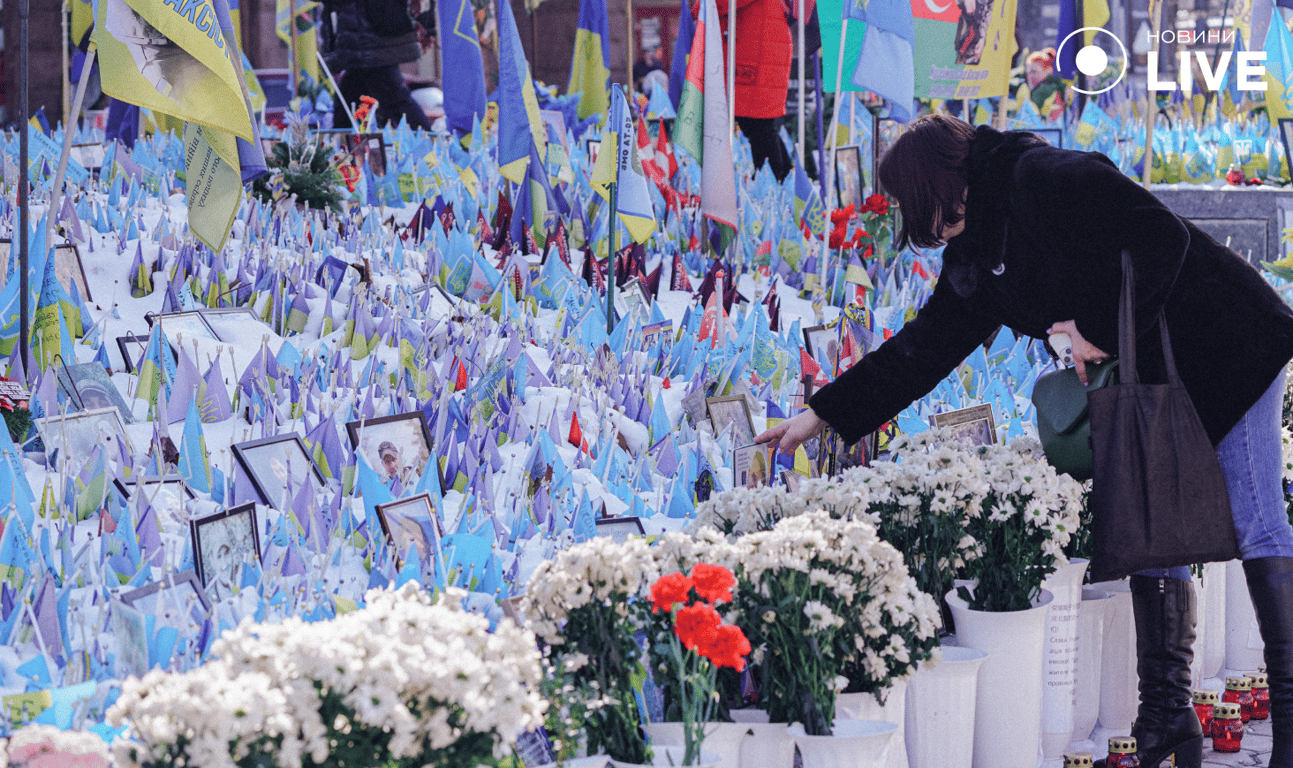 Люди біля прапорців на честь загиблих військових на Майдані
