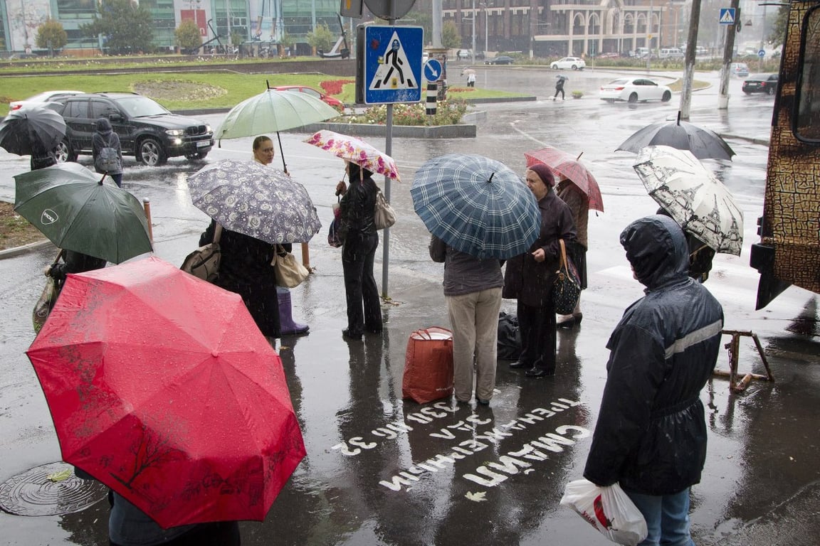 Люди під парасолями у дощ