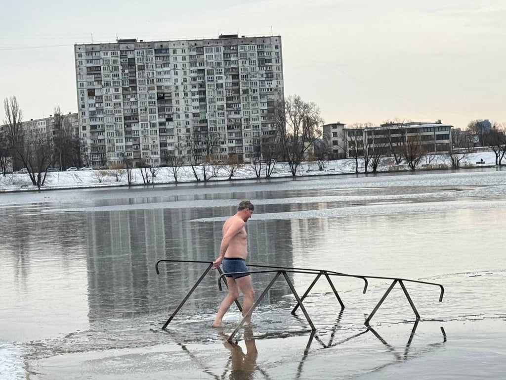 Человек купается в ледяном озере.