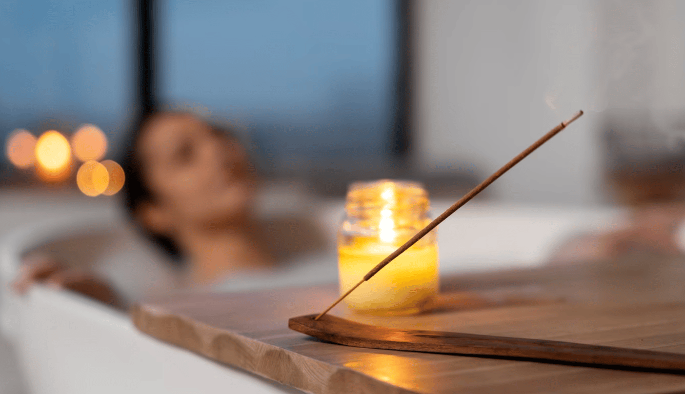 Девушка, принимающая ванну при свече и ароматической палочке.