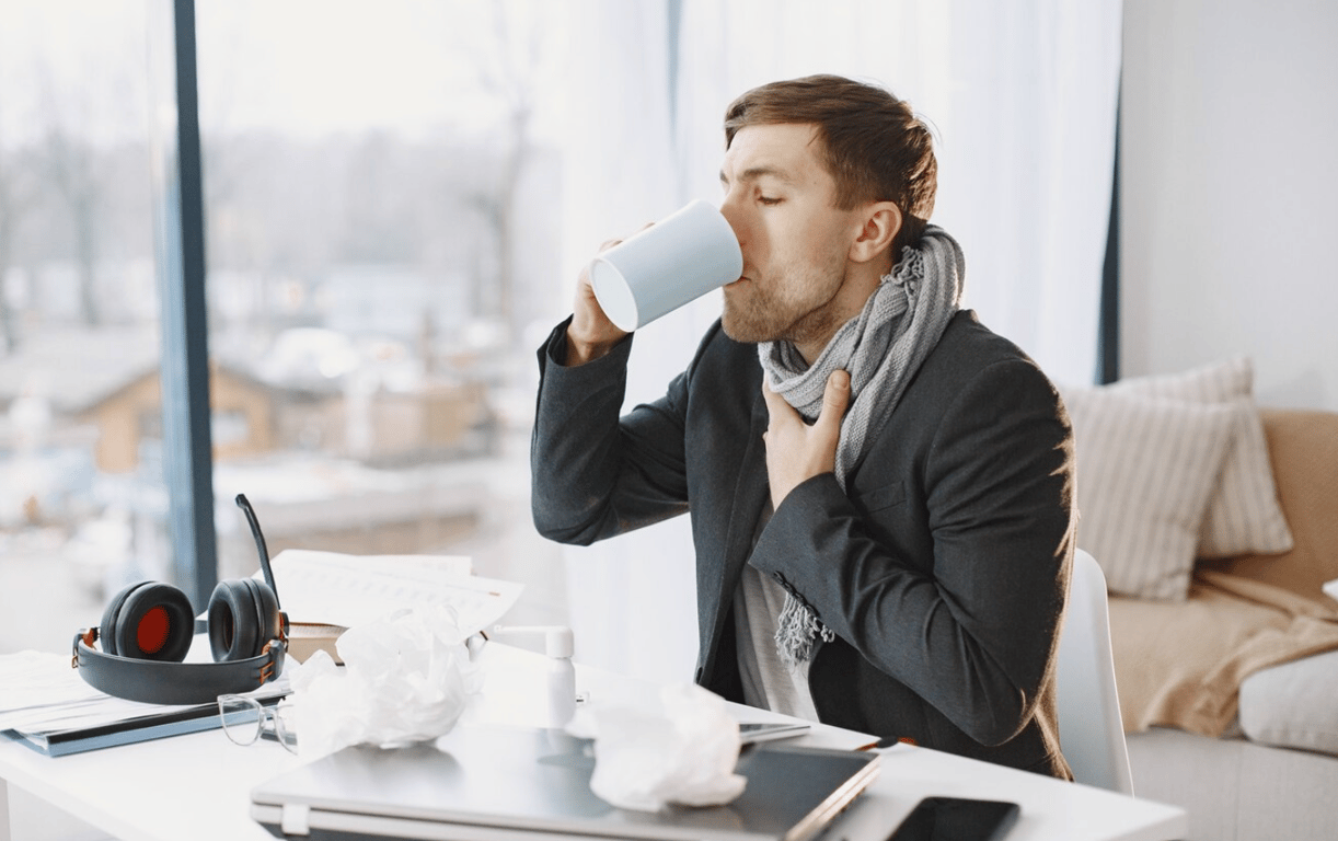 Мужчина, который пьет чай от простуды