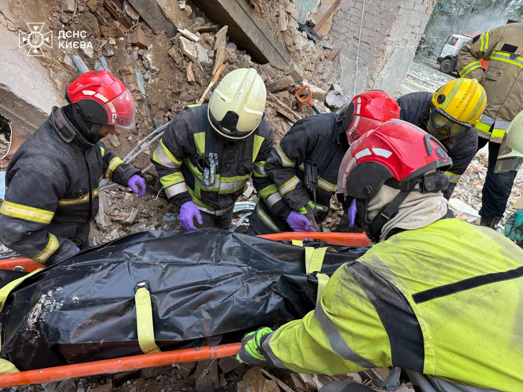 Rescuers remove bodies from the rubble in Solomyansky district