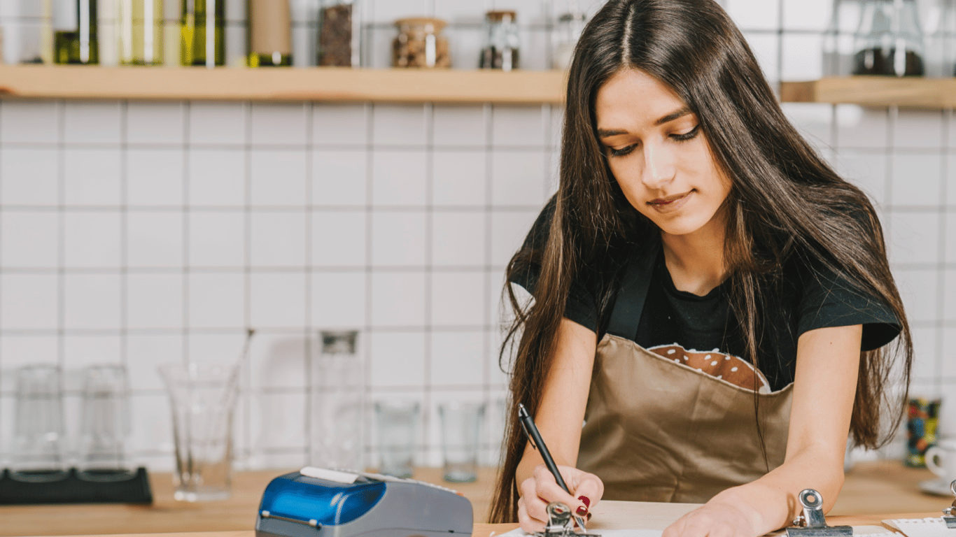 Дівчина записує щось в блокнот