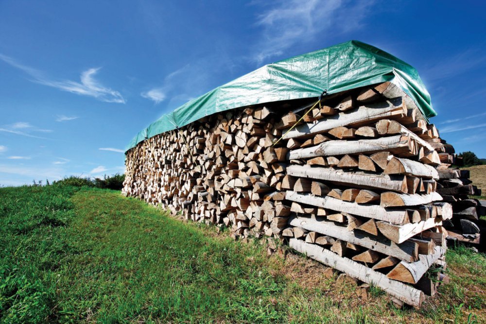 Купа накритих дров на вулиці.