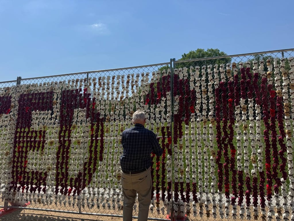 Чоловік біля композиції з іграшкових ведмедиків 