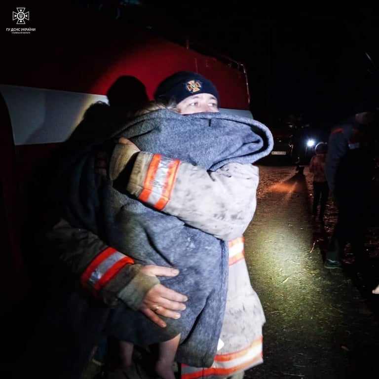 Спасатель со спасенным ребенком в Киевской области