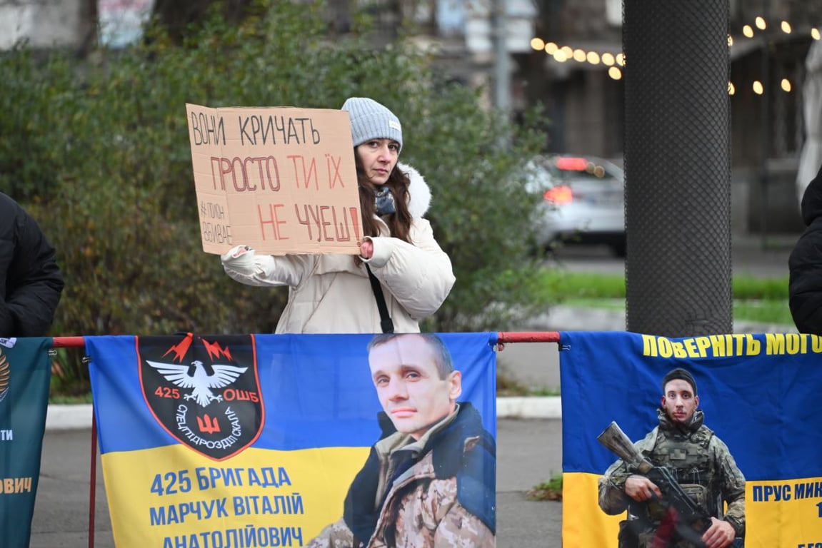 Жінки та чоловіки тримають фото своїх рідних, які перебувають у полоні.