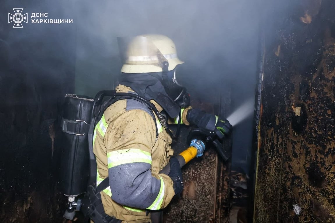 Рятувальник поливає вогонь у квартирі