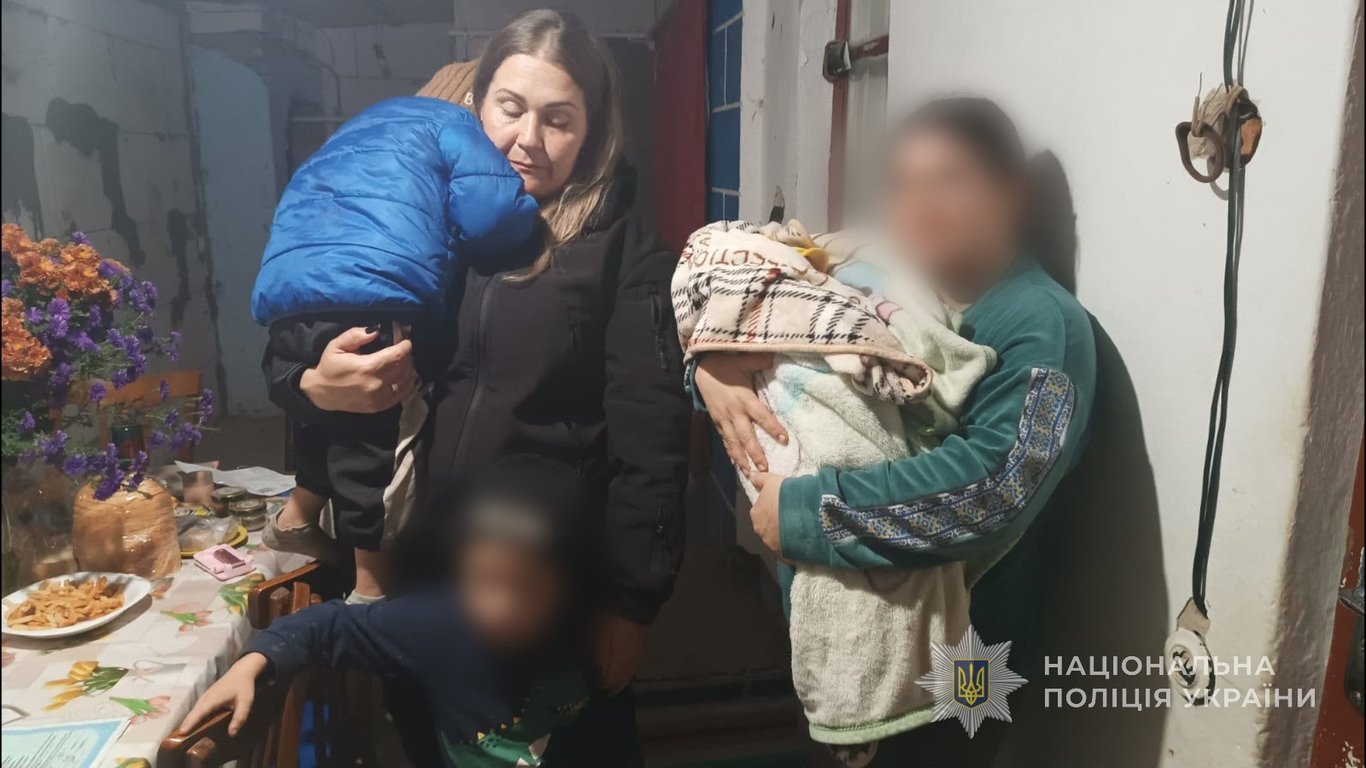 Поліцейська тримає дитину на руках під час перевірки умов проживання родини на Одещині