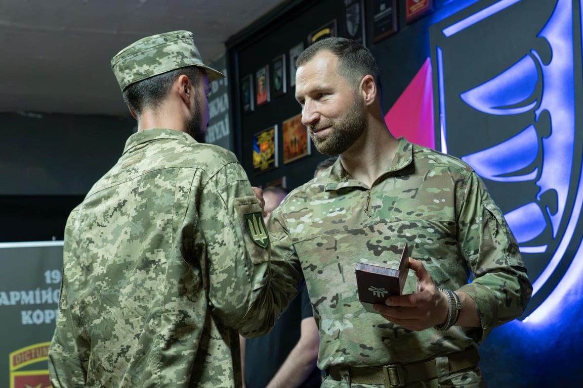 Євген Хмара вручає воїну нагороду