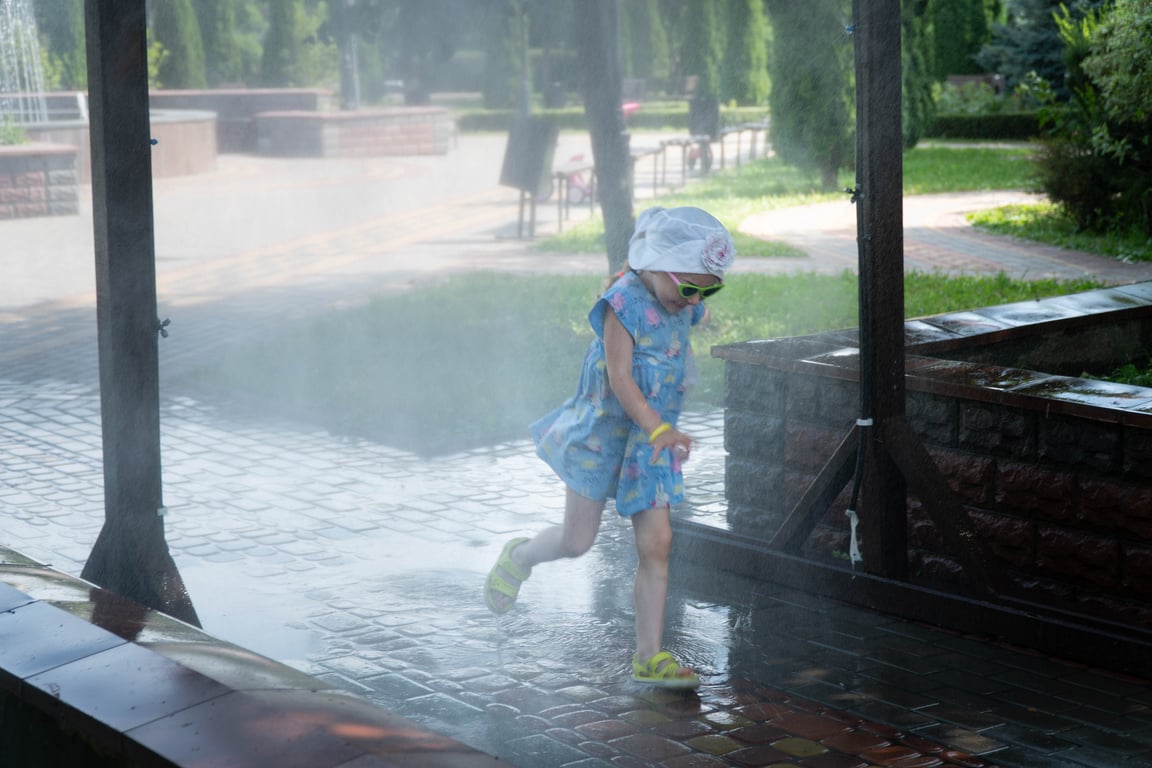 Дитина під рамкою-розпилювачем води в Києві