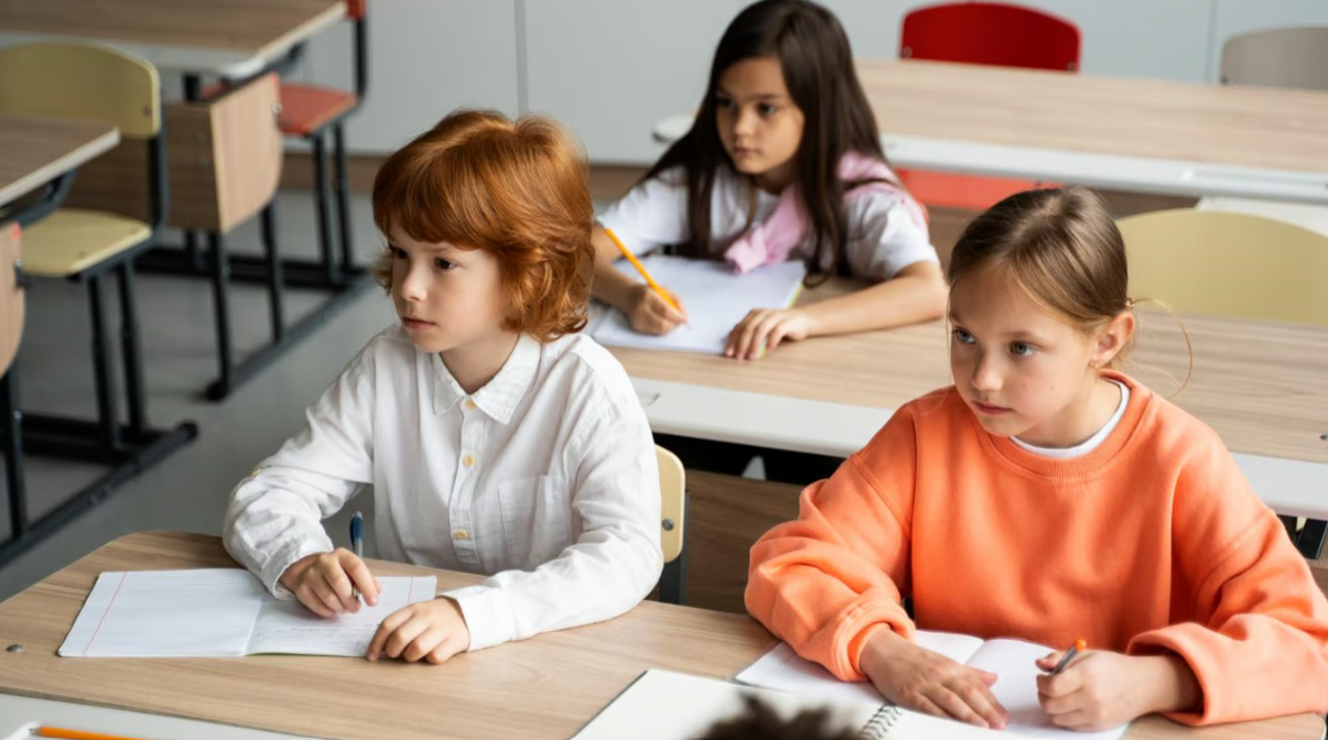 Діти за шкільними партами. Фото: freepik.com