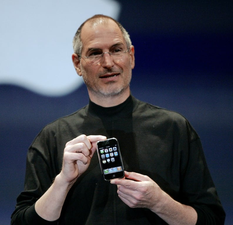 Steve Jobs holding the first iPhone