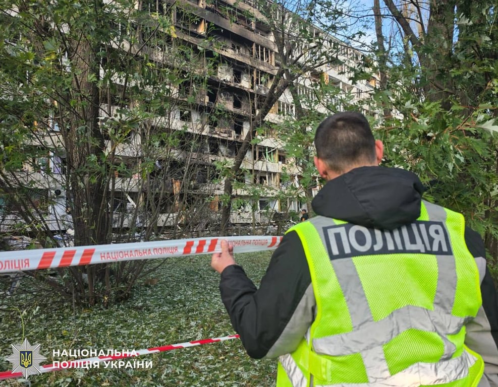 Поліцейський на тлі зруйнованого Росією багатоквартирного житлового будинку в Деснянському районі Києва 14 жовтня 2026 року