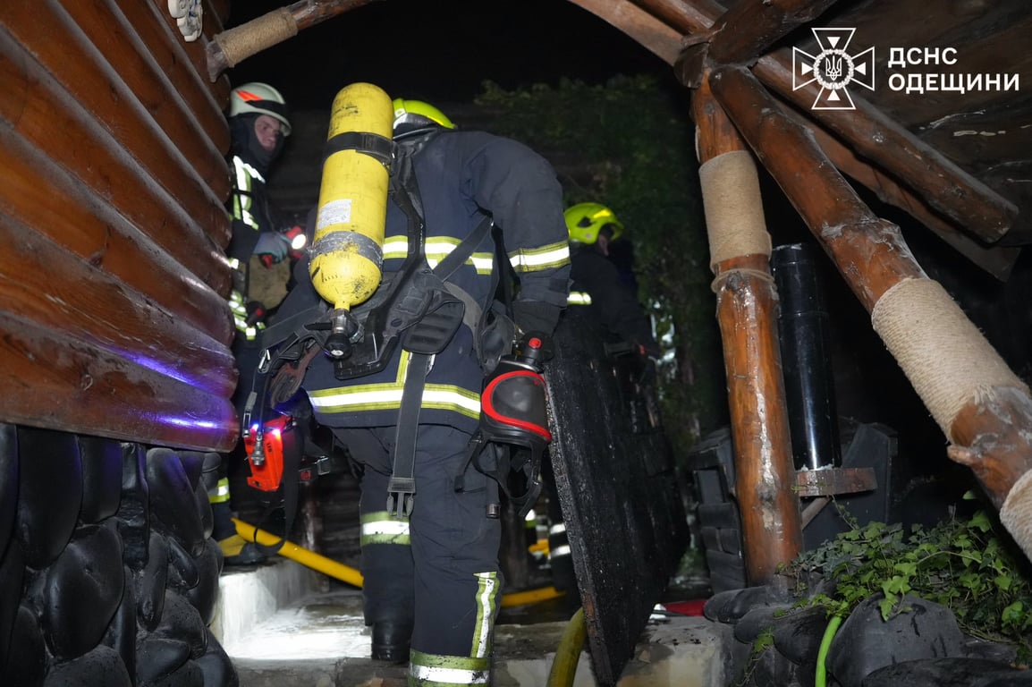 Рятувальник зі шлангом гасить пожежу