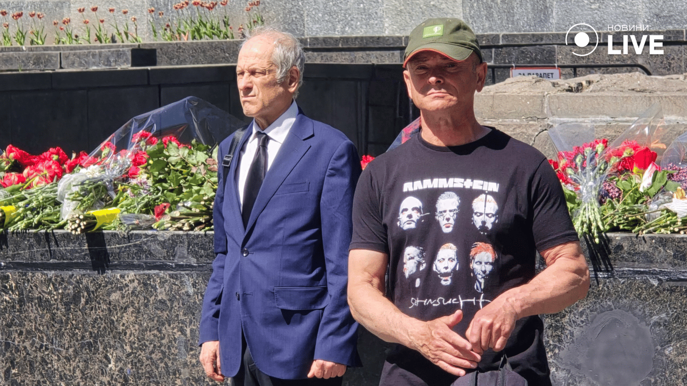 Чоловіки стоять біля меморіалу в Харкові