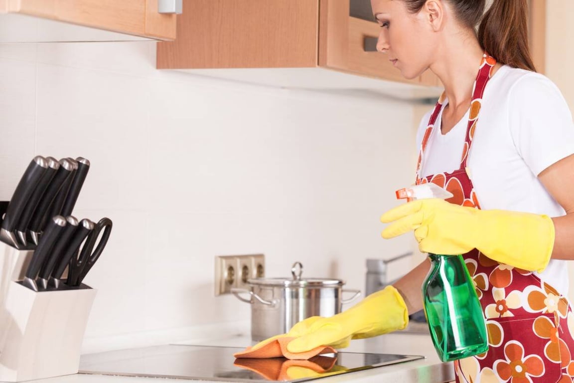 Женщина, чистящая фасады на кухне
