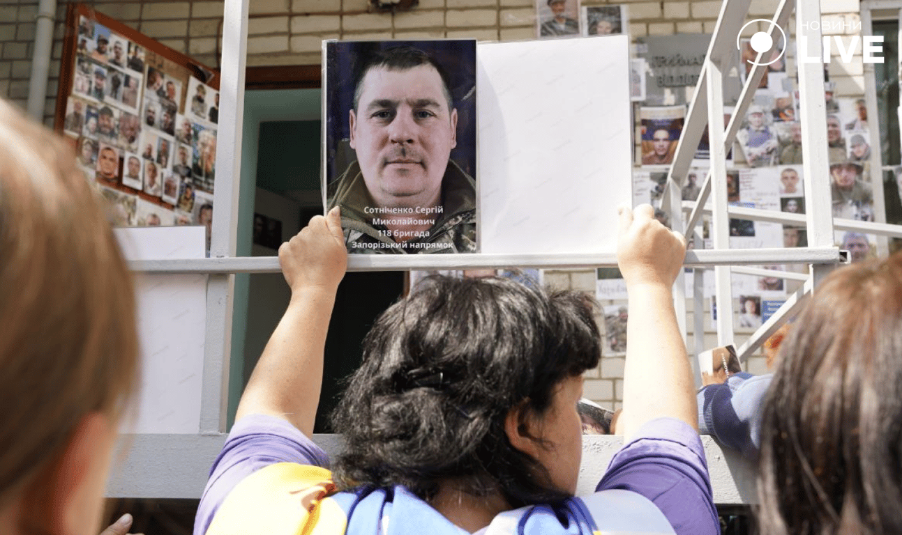 Жінка тримає фото свого брата, який перебуває у полоні