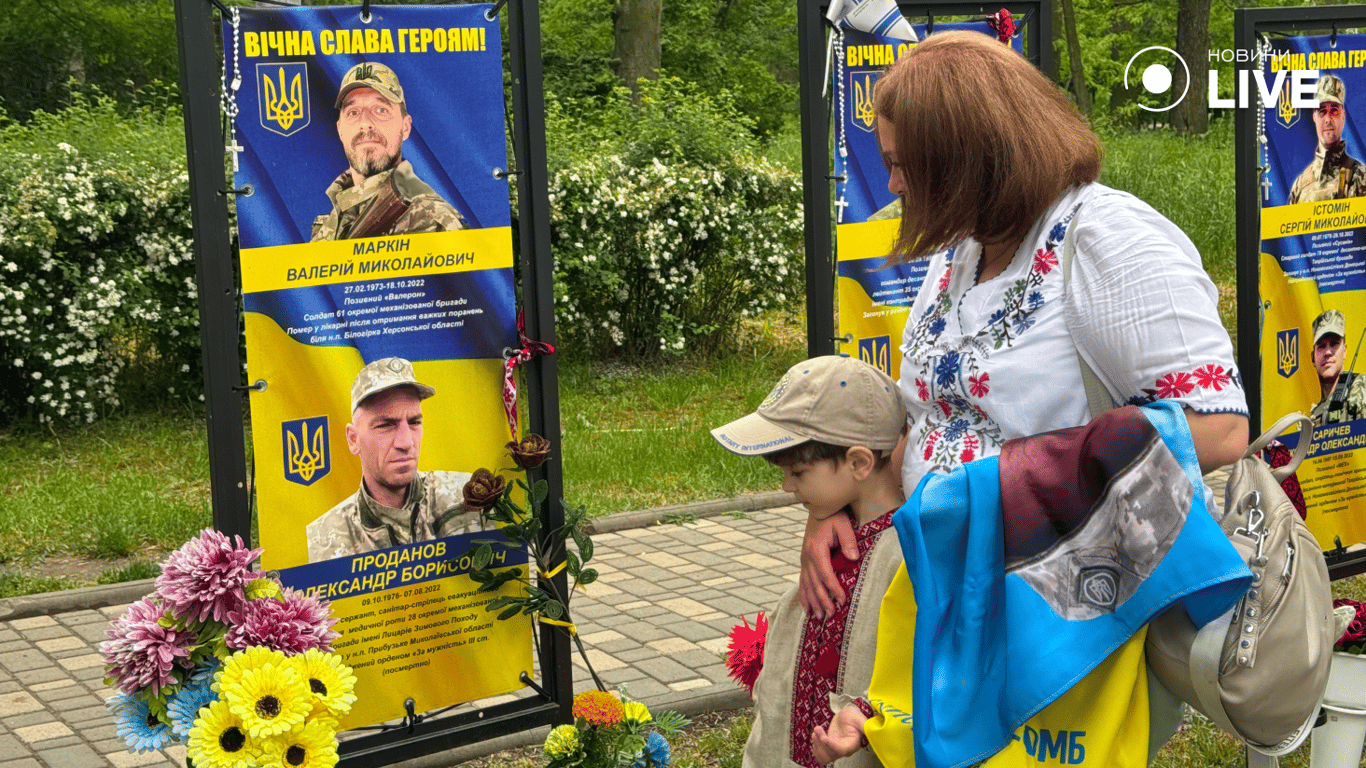 Женщина с ребенком возле портрета.