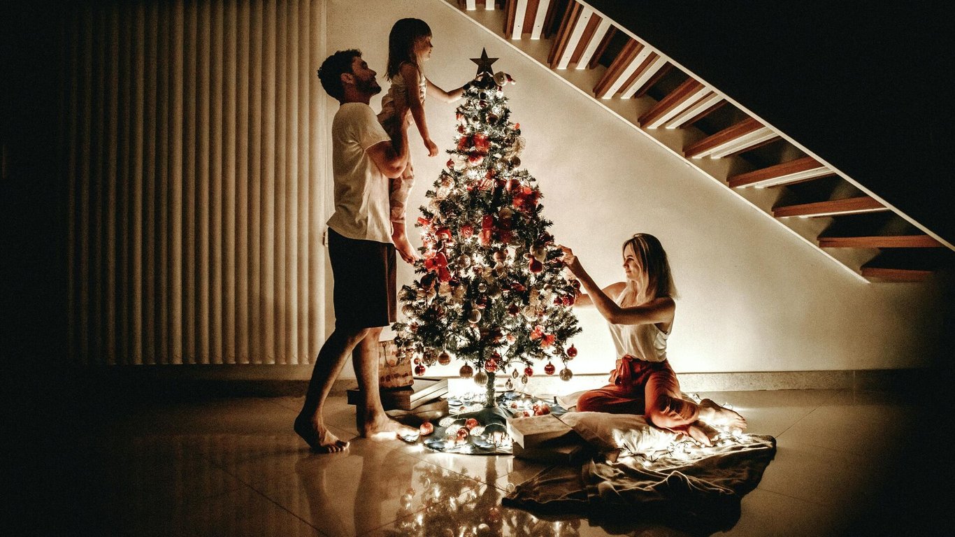 Семья, украшающая новогоднюю елку