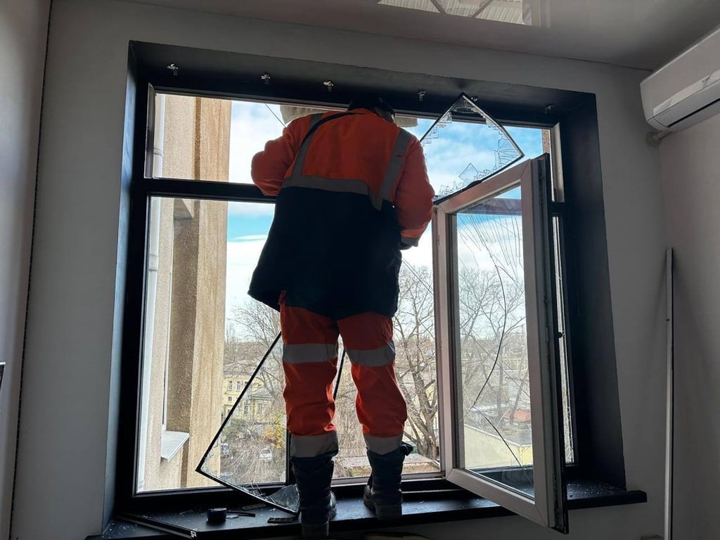 Комунальник завішує розбите вікно