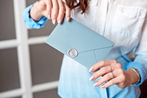 Женщина, держащая в конверте сертификат