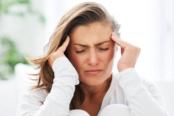 Женщина страдает от головной боли