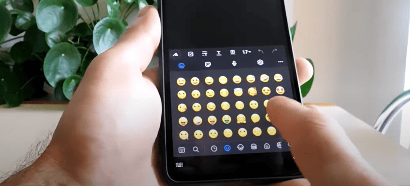 Мужчина, показывающий смайлики в своем телефоне