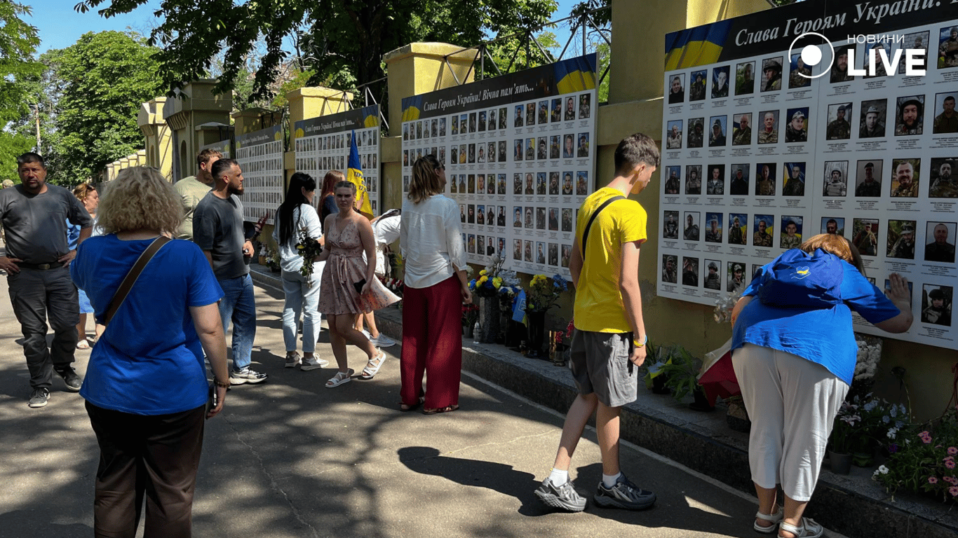 Люди покладають квіти до Стіни пам'яті загиблих захисників в Одесі