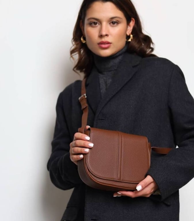 Коричневая сумка может стать отличным дополнением образа.