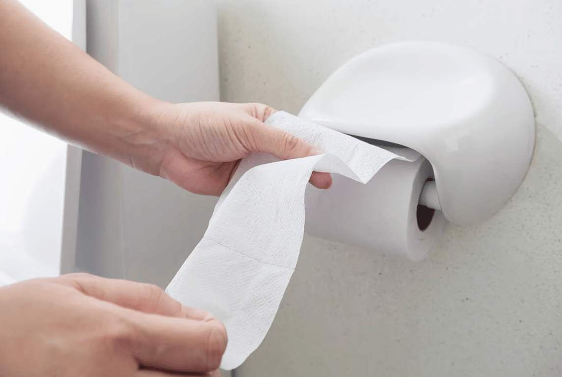 Человек, использующий туалетную бумагу