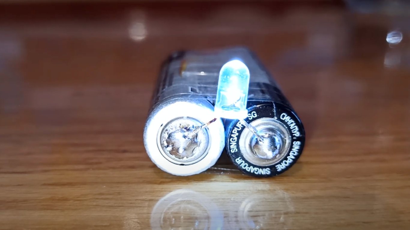 Світлодіод, під’єднаний до батарейок, світиться як саморобний ліхтарик.