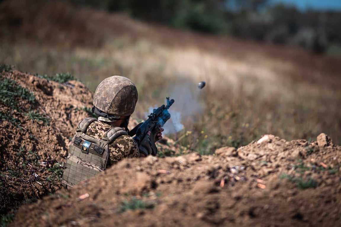 Український захисник стріляє по позиціях ворога