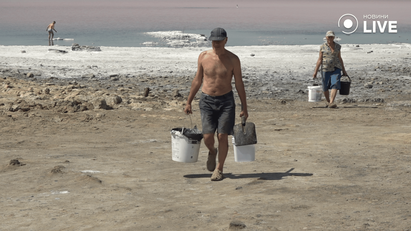 Люди несуть куяльницьку грязь у відрах