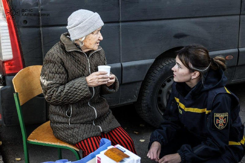 Рятувальник допомогає постраждалій бабусі