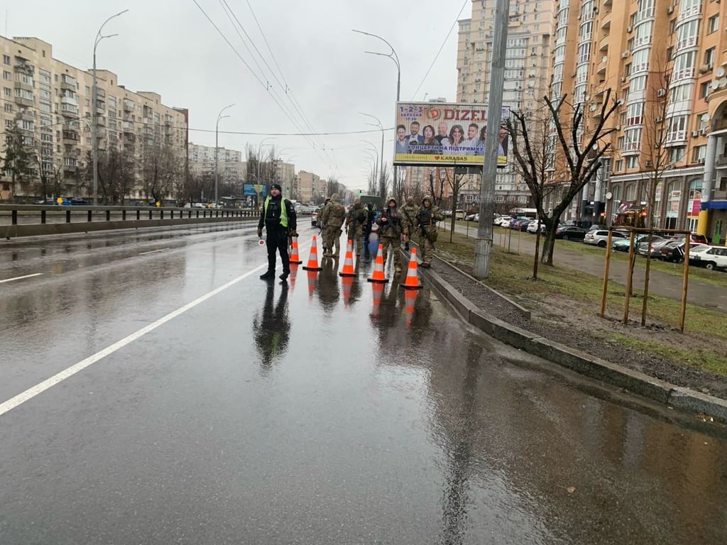 Полицейский и военные на блокпосте в Киеве