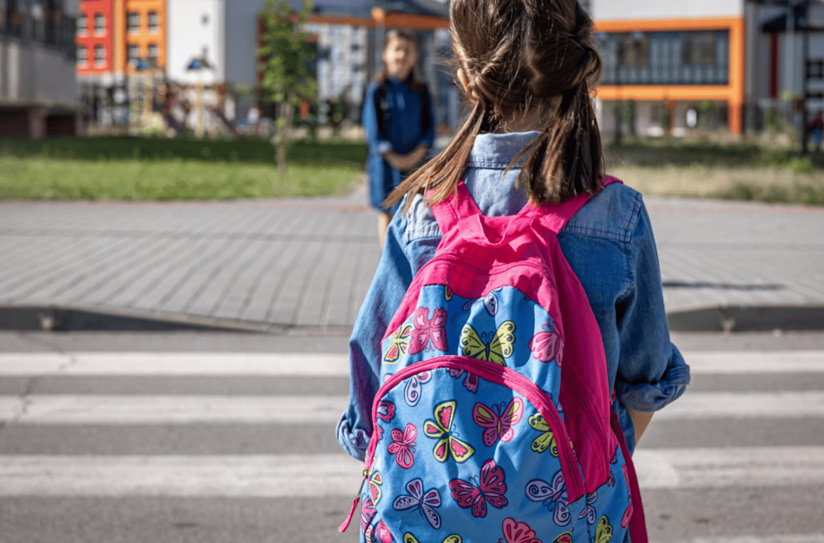 Ребенок, который держит на спине рюкзак