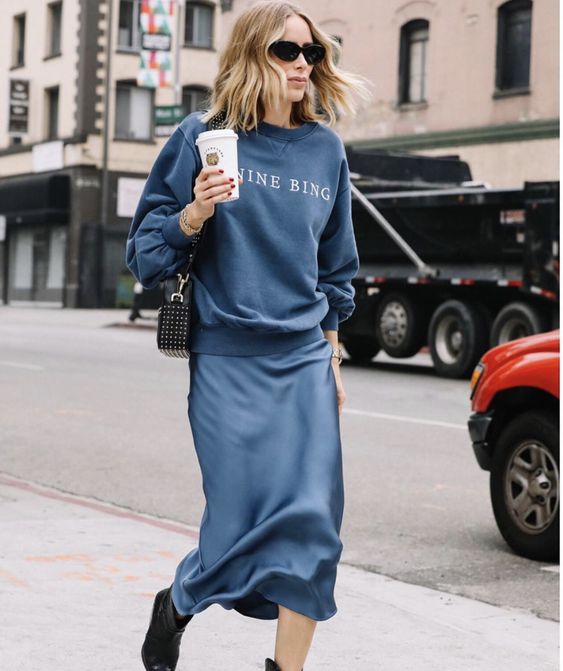 Молодая женщина в джемпере и шелковой юбке