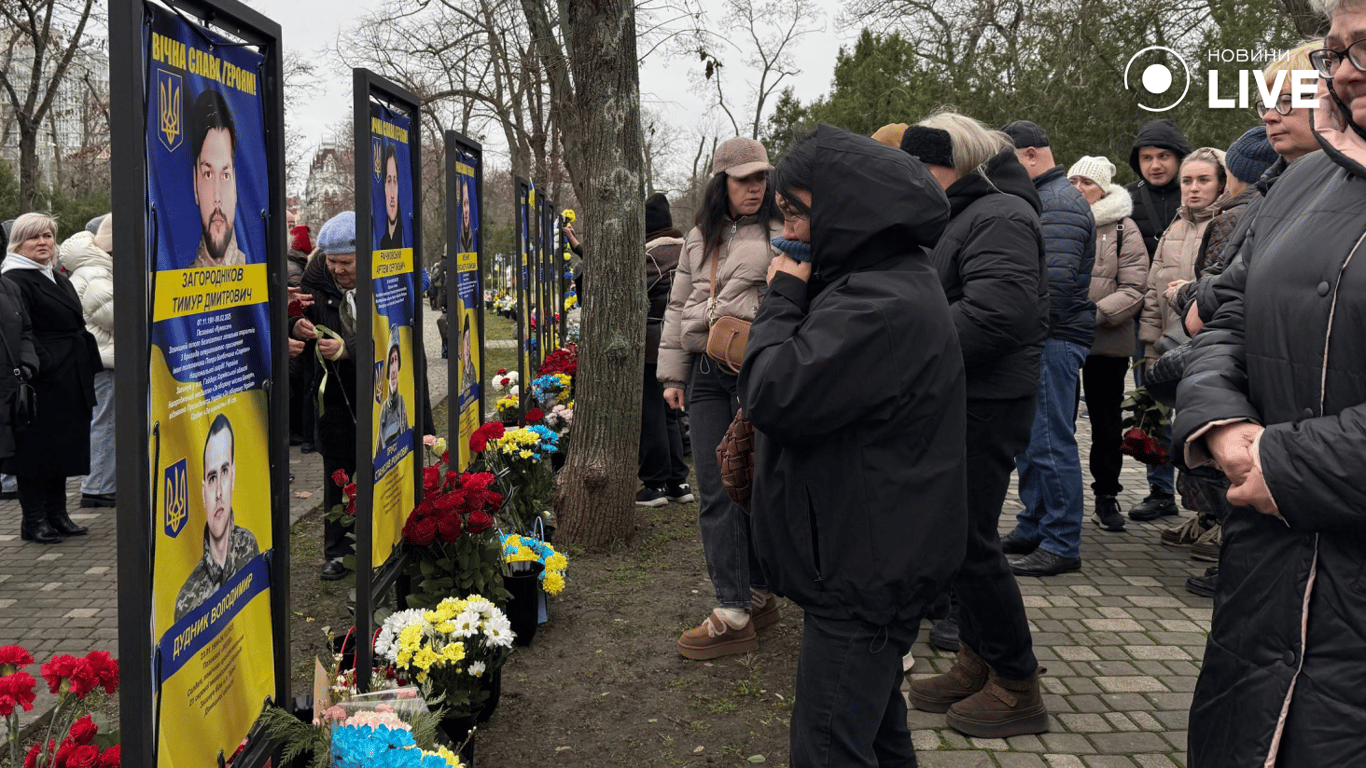 Люди біля портретів полеглих захисників
