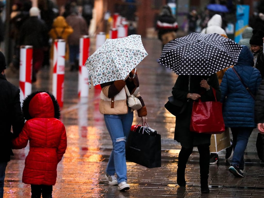 Люди на вулиці ходять під парасольками під час дощу