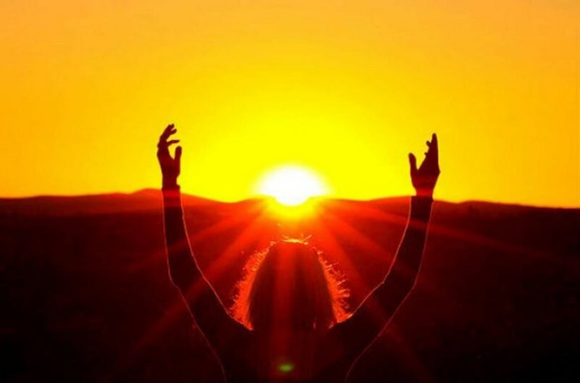 Жінка медитує на заході сонця