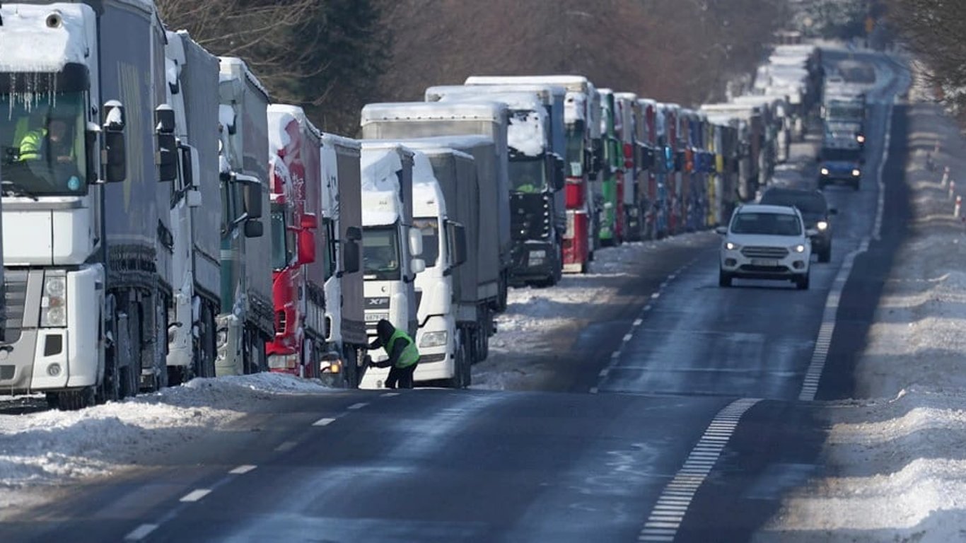 Поляки высыпают зерно из украинских грузовиков,  которые стоят на границе